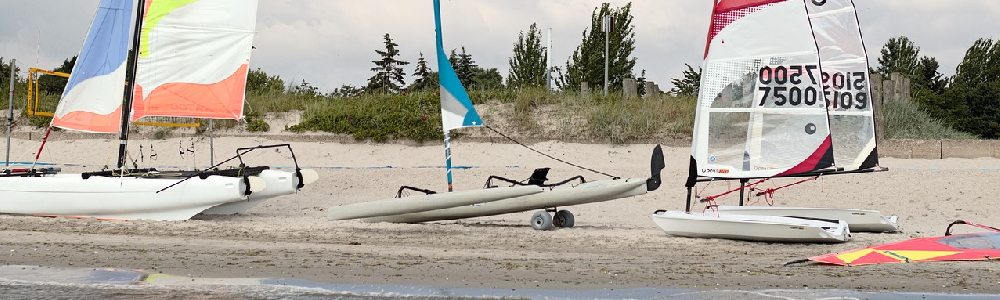 Surfschule und Segelboote am Strand von Kellenhusen